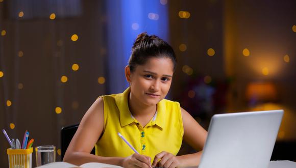 Estudiante de la Academia Pitágoras concentrada en sus estudios preuniversitarios a través del aula virtual por la noche